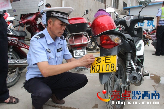 圖為望謨縣交警隊(duì)民警正在為群眾安裝摩托車牌照 (1).jpg